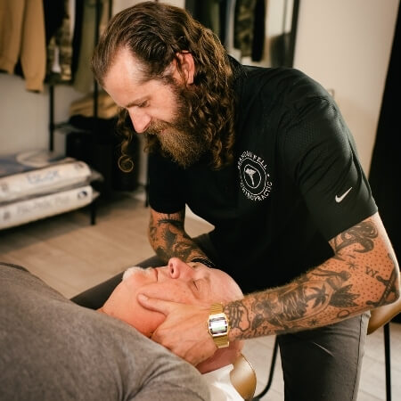 Male patient receiving a chiropractic neck adjustment