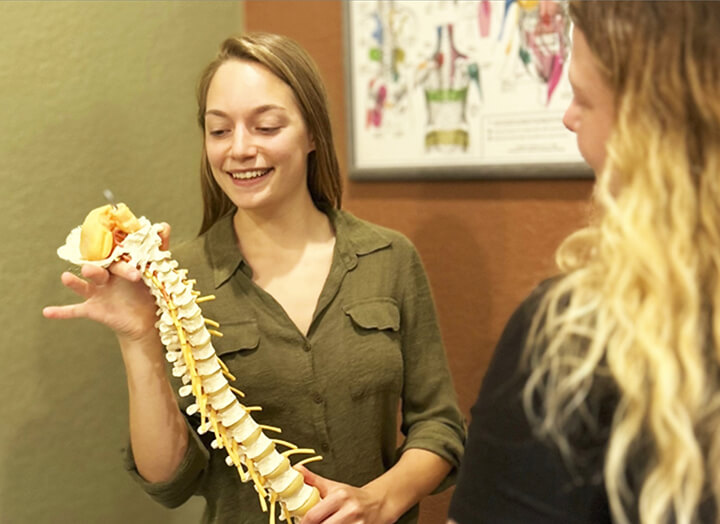 Doctor showing spinal model to patient