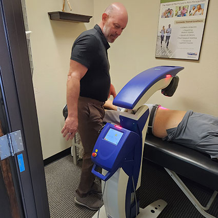 Dr Todd using laser therapy on patient