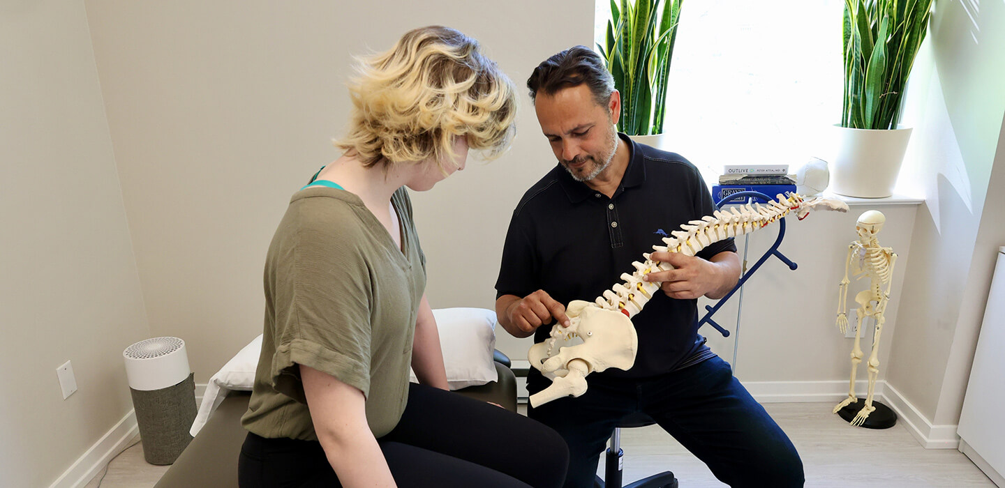 Chiropractor showing spine model to patient