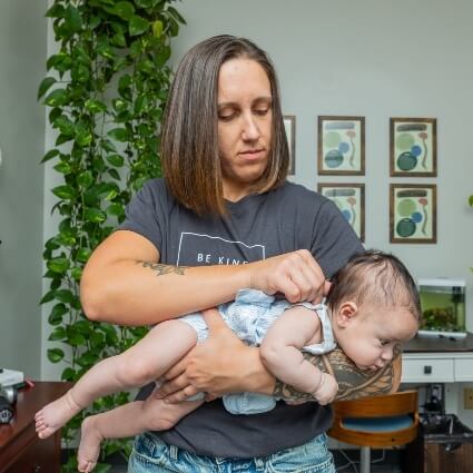 baby being held while adjusted