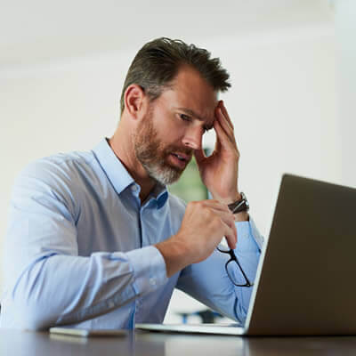 man headache in from of computer