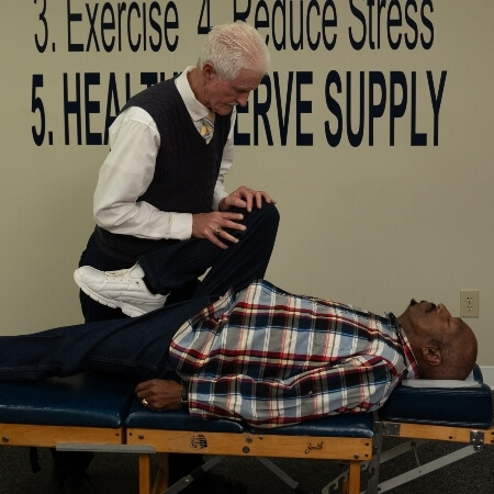 Male patient receiving a chiropractic leg adjustment