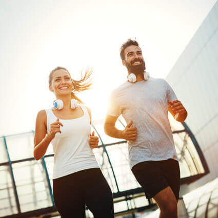 couple-running-together-headphones-around-neck-sq