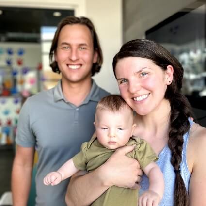 mom and dad with baby smiling