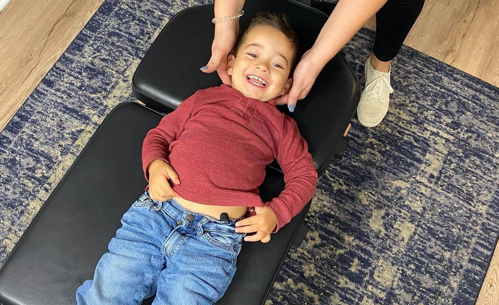 smiling kid being adjusted by South Austin chiropractor