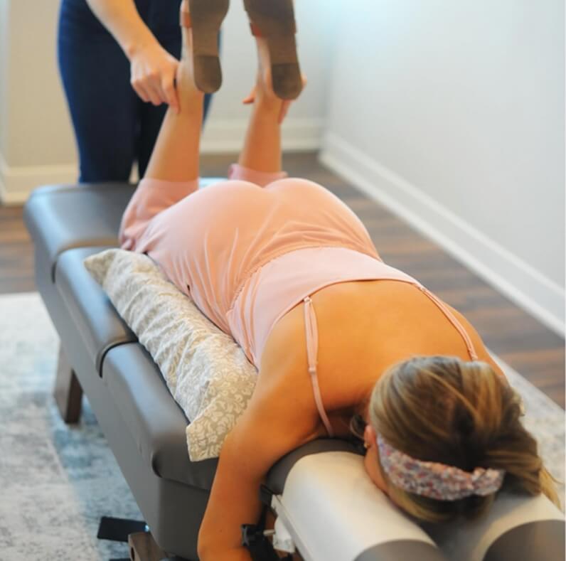 child laying on table having legs examined