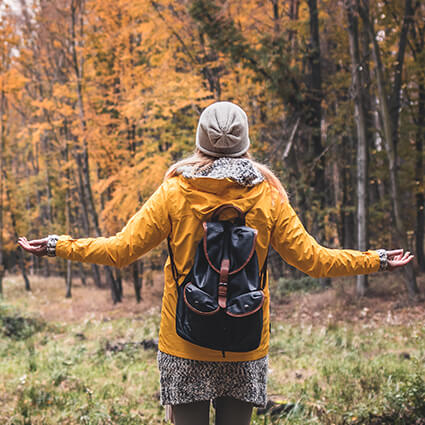 person outdoors with arms outstetched