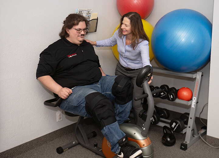 Chiropractic helping patient use exercise equipment