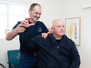 chiropractor adjusting patients shoulder