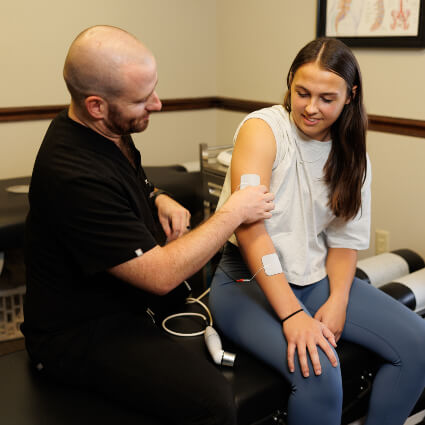 Dr. Brad attaching muscle stimulator tabs