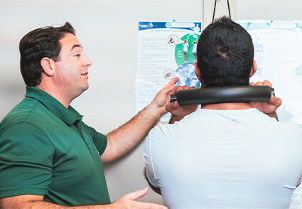 chiropractor explaining anatomical chart to patient