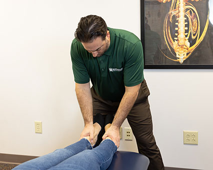 Dr. Aaron Wahl adjusting patient's legs