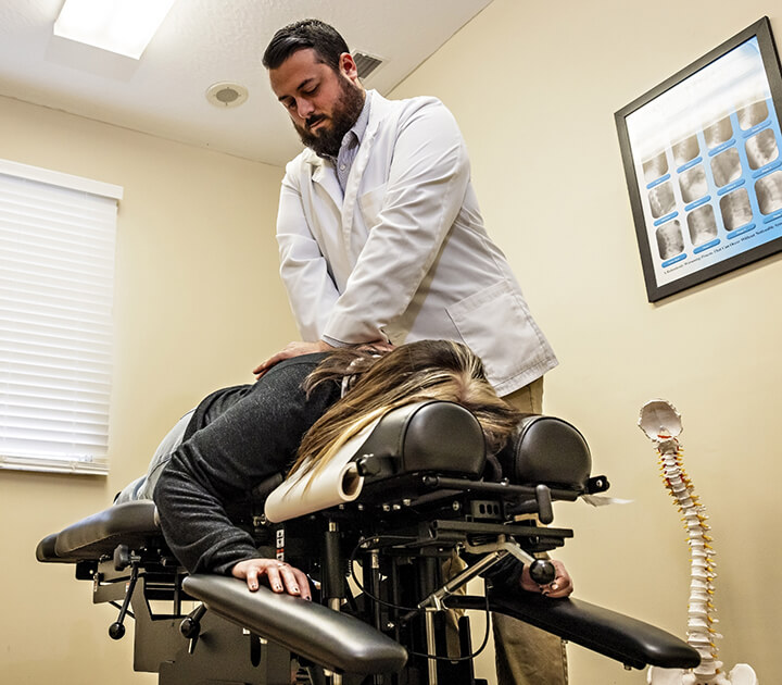 Chiropractor adjusting patient on table
