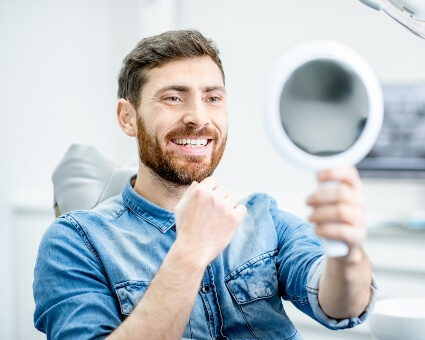 Man looking at a mirror to admire his smile