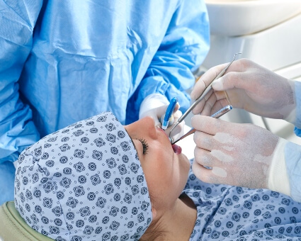 Dentist performing oral surgery