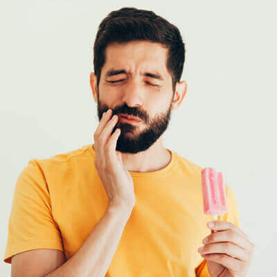 Man eating popsicle with mouth pain