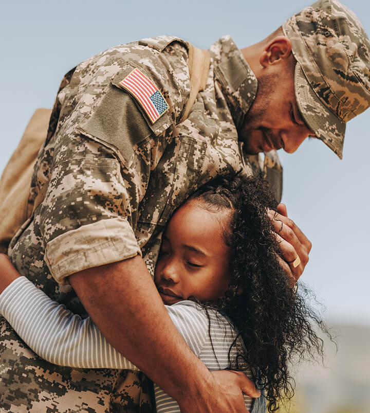 Military father hugging daughter