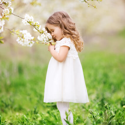 Little girl smelling flowers