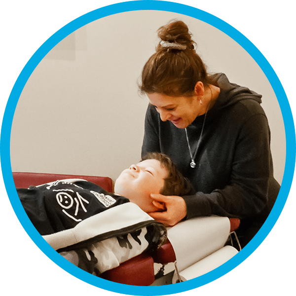 Chiropractor adjusting child patient with tool