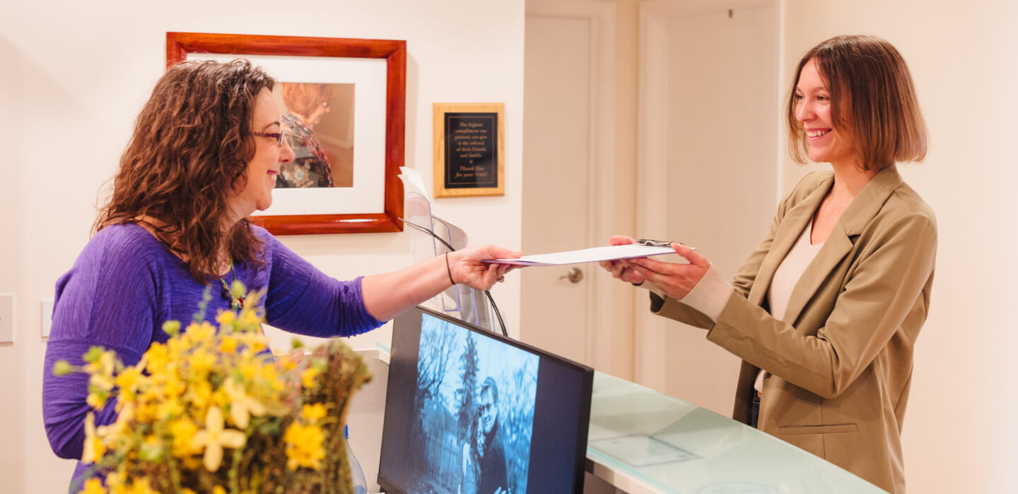 Haug Chiropractic patient handing in paperwork at front desk