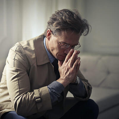 person sitting on couch looking worried