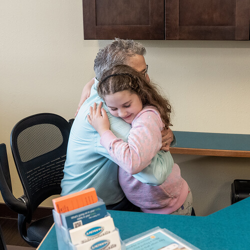 Dr. Ludwig hugging kid patient