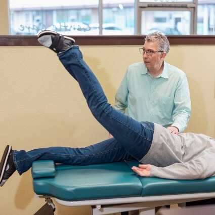 Bonney Lake chiropractor Dr Ludwig checking patients legs