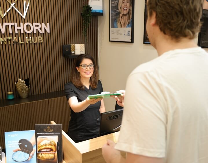 Hawthorn East dentist Dr Nina Madlani handing over form to patient