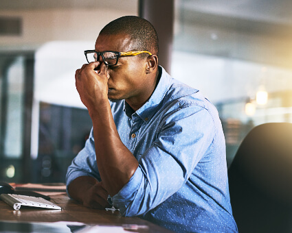 Man sitting in office with severe headache