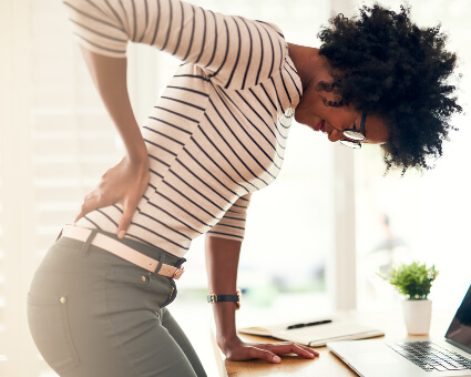 Woman in office with sciatica pain