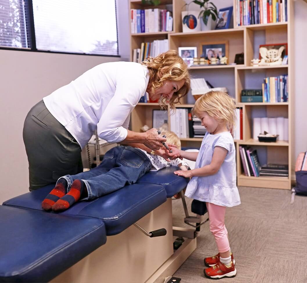 Colorado Springs Chiropractor Dr. Lynn Cash using activator on child
