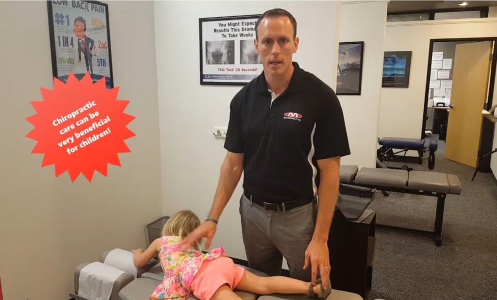 Dr. Tim giving a chiropractic adjustment to a young child
