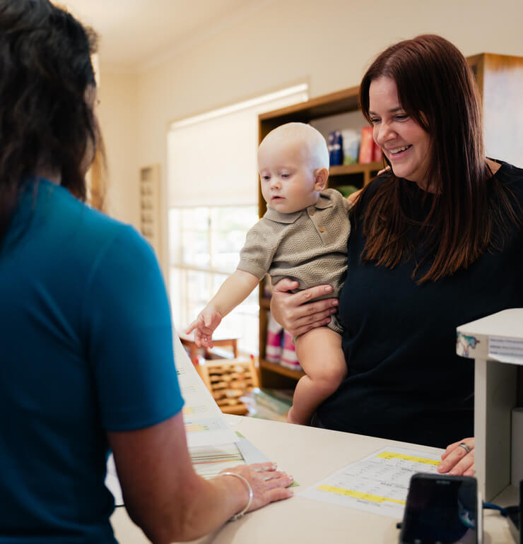 Mother with child signing form