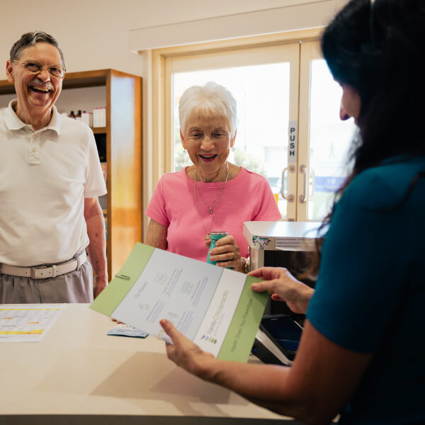 Patients and receptionist laughing together