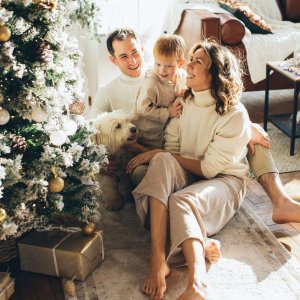 A happy family celebrating Christmas morning with a decorated tree and gifts.
