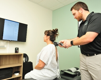 New Practice Members Chiropractor using scanning device on patient