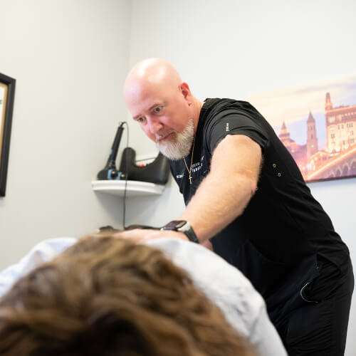 Chiropractor adjusting patient's upper-back