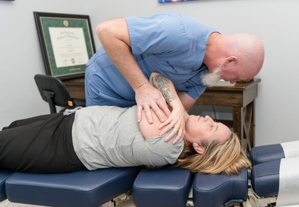 Chiropractor adjusting patient's shoulder