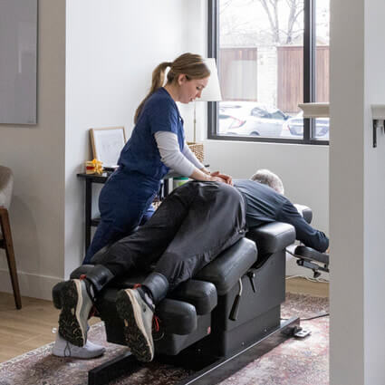 female chiro adjusting old woman on a table