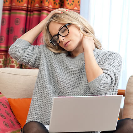 woman on couch with neck pain