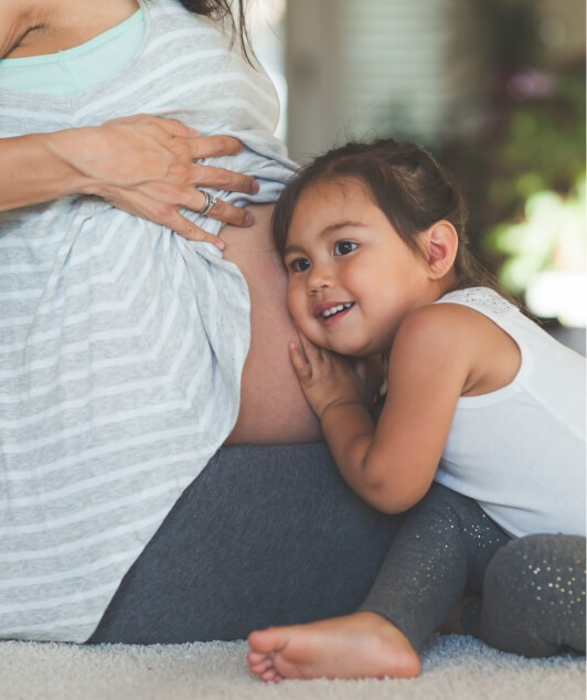 child resting on mom's pregnant belly