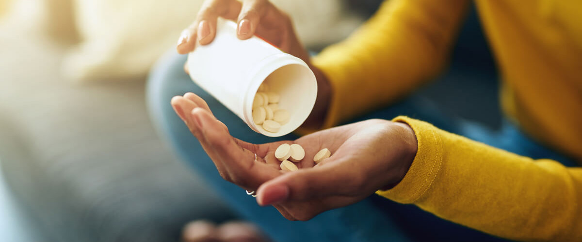 person pouring supplements into hands