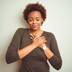 greateful woman with hands on heart