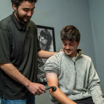 O'Hara Family Chiropractic practitioner using tool on patients arm