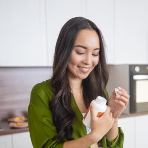 woman inspecting supplemenets bottle