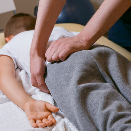 young boy lying on stomach for hip adjustment