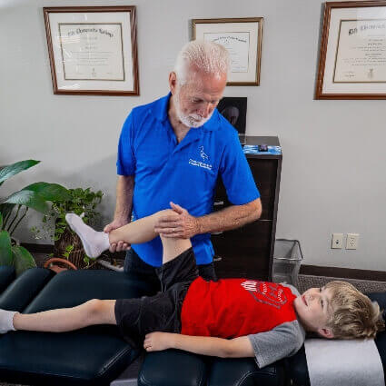 Dr. Philip Adjusting a Boy's Knee