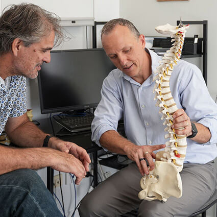 Dr Mathew explaining spine model to patient