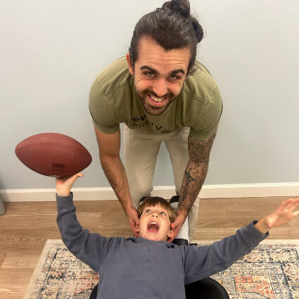 Kid getting adjusted holding football